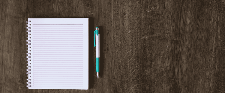 notebook and pen on wood table